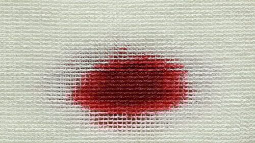 Red Stain Spreading on Textured White Material