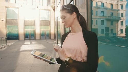 Woman Using Tablet Outside Modern Office Building