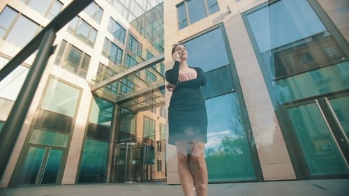 Young Woman Talking on Smartphone Outside Office Building