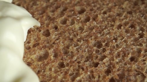 Cream Cheese Being Spread on a Slice of Bread