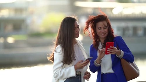 Two Townswomen in City at Sunny Weather, Ladies Are Standing on Embankment and Viewing Pictures in
