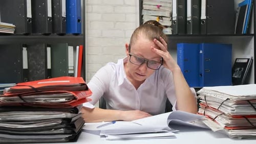 Tired businesswoman working with documents in office