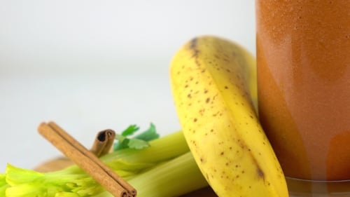 Smoothy à l'orange en verre. Banane, carotte, persil, céleri