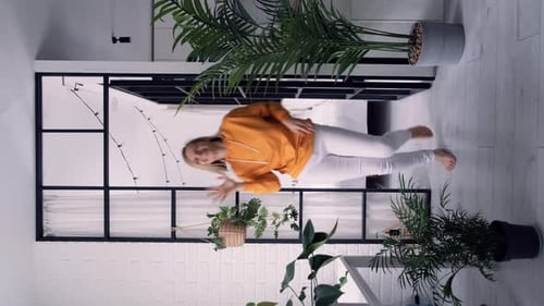 Energetic Blonde Woman Dancing in Modern Home