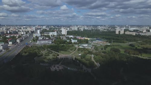City landscape. Nearby there is a park area. Blue sky with white clouds. Aerial photography.