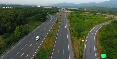 Aerial View of Highway with Cars Amidst Green Landscape