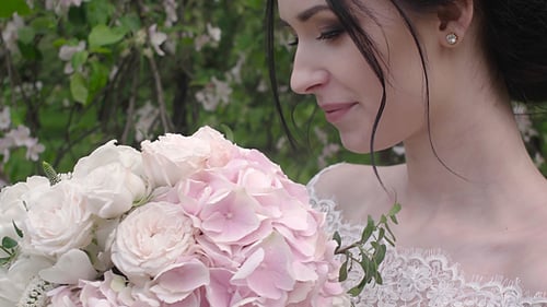 Smiling Woman with Wedding Bouquet in Springtime Setting