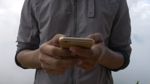 Mann tippt auf dem Smartphone