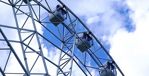Giant Ferris Wheel Rotating Against Blue Sky