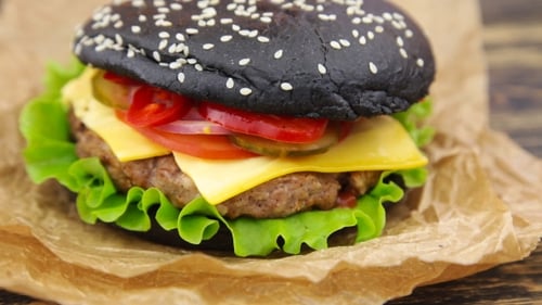 Delicious Black Bun Burger with Cheese and Vegetables
