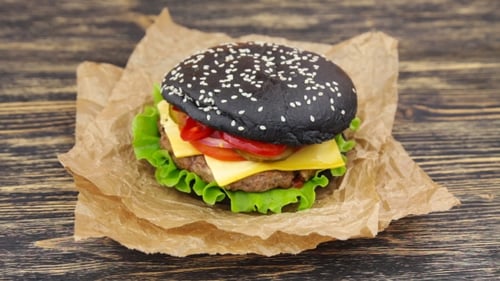 Delicious Burger with Black Bun and Fresh Ingredients
