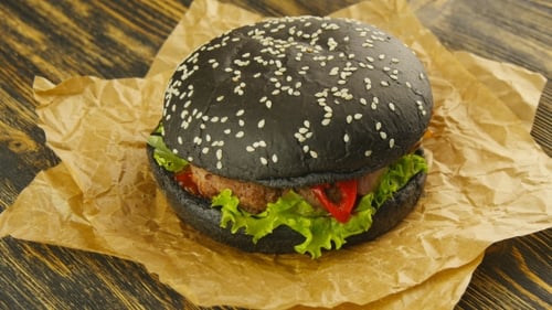Black Burger with Lettuce on Parchment Paper