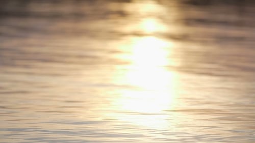 Auf dem Wasser reflektierte Sonnenstrahlen