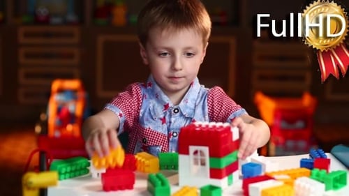 Junge spielt mit farbigen Stücken