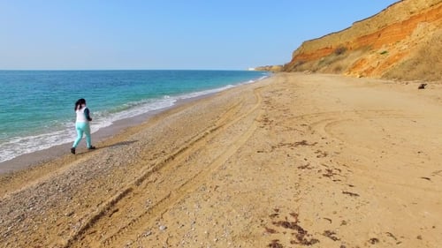 Woman Jogging Along Beach