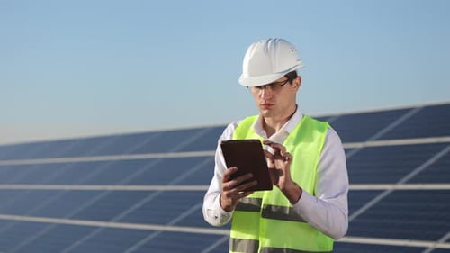 Der Ingenieur steht neben den Sonnenkollektoren