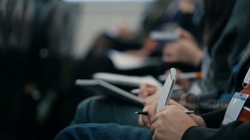 Adults Taking Notes in a Dark Room