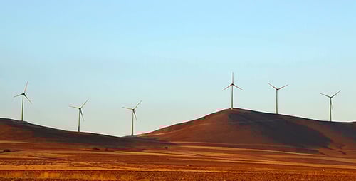 Wind Turbines Spinning on Rural Hillside at Sunset