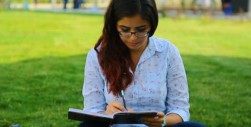 Woman Writing in Notebook Outdoors