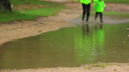 Cute Girl And Boy Having Fun In Huge Puddle