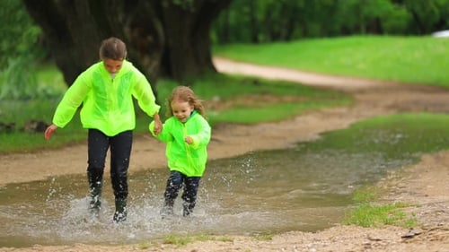 Enfants mignons courir dans une énorme flaque d'eau