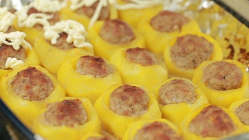 Vegetables and Meatballs Dish Being Topped with Sauce