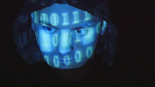 Quellcode projiziert über das Gesicht eines wütenden feindlichen Mannes, schwarzer Hintergrund.