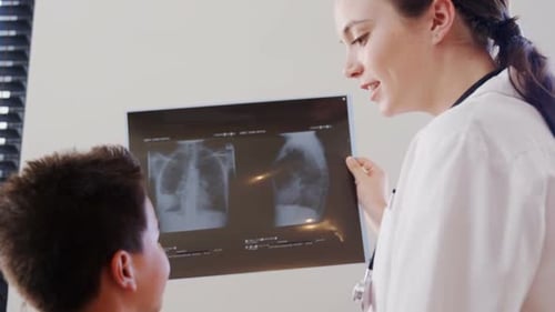 Friendly Doctor Explains X-Ray to Child Patient