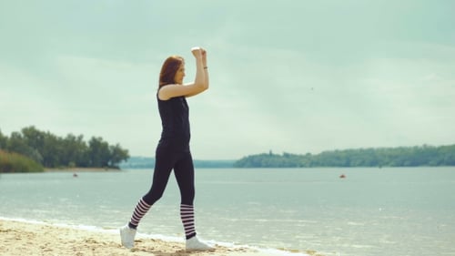 Beautiful Red-haired Girl Doing Exercises on the River.