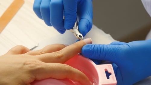 Manicurist Trimming Nails in a Professional Setting
