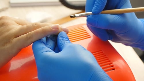Manicurist Applying Clear Coat to Fingernails