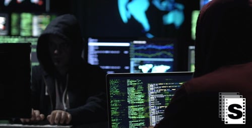 Hooded Coder Working at Multiple Monitors