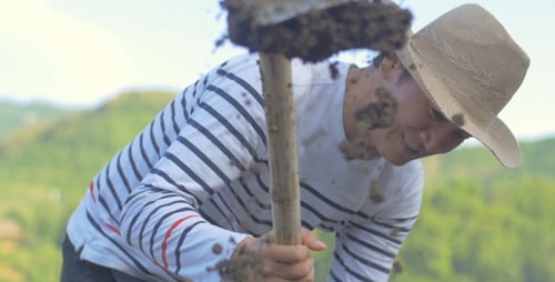 Man Digging in Rural Landscape with Shovel
