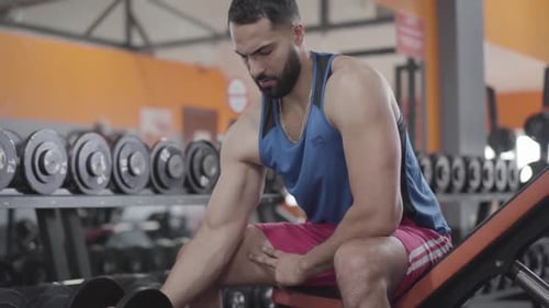 Konzentrierter Sportler hebt Hantelgewichte im Fitnessstudio