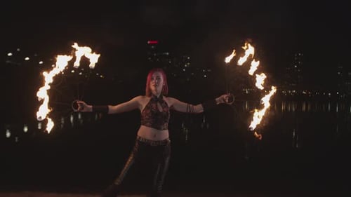 Artist Creating Fire Circle Spinning Fans at Dusk