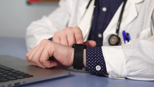 Close Up Shot of the Doctor's Hand, Who Uses a Smart Watch To Check a Mail