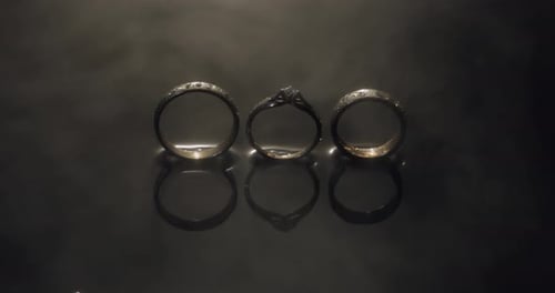 Elegant Wedding Rings Reflect on Black Surface