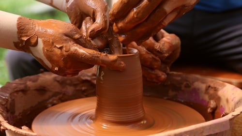 People Working with Clay on Potter's Wheel