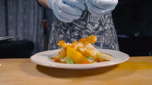 Chef Plating Dish of Grilled Shrimp and Vegetables
