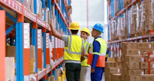 Male and female warehouse worker inspecting stock