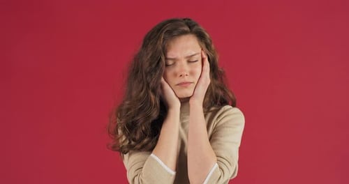 Young Beautiful Girl Teenager Woman with Long Hair Feels Headache Holding Her Forehead with Her Hand
