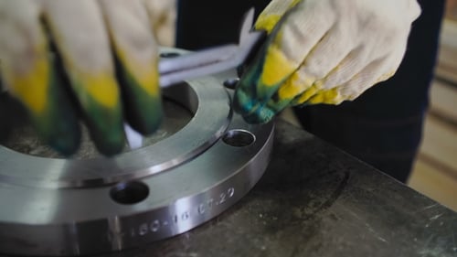 Le travailleur mesure le diamètre avec l'étrier à bride