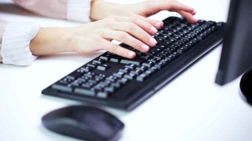 Frau tippt auf Computertastatur im Büro 52