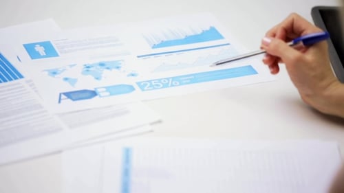 Businesswoman Reviewing Documents and Making Notes