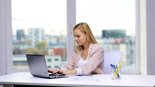 Woman Works at Desk with Laptop in Office