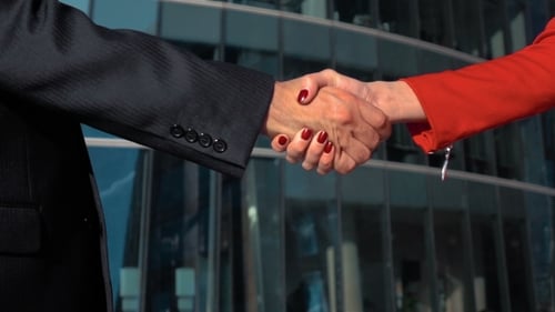 Confident Handshake Outside a Corporate Office Building