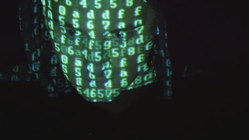 Male Face of Hacker With Binary Code Projections. Source Code Projected Over an Angry