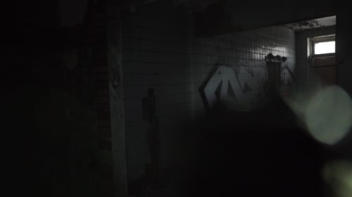 Soldier With a Gun And a Laser Sight Searching Dark Ruined Building