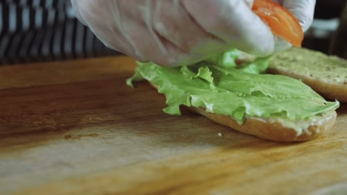 Preparing Open Faced Sandwich With Lettuce and Tomato