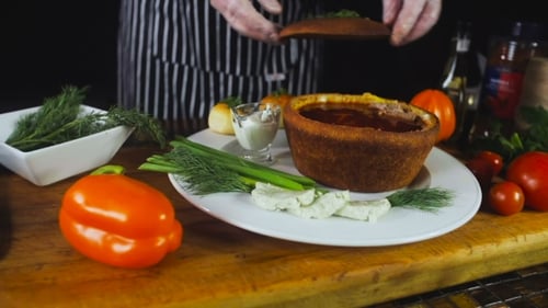 Chef Preparing Soup in Bread Bowl with Vegetables